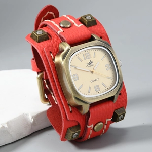 Detail of red leather cuff watch with bronze studs and coarse white stitching