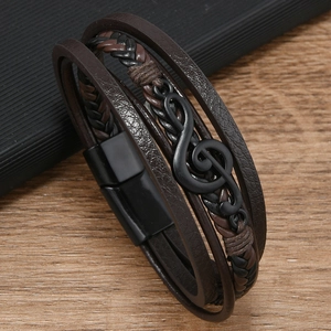 Detail eines mehrlagigen Lederarmbands mit mattem schwarzem Violinschlüssel und Magnetverschluss