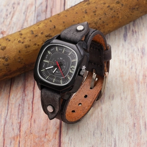 Macro shot of square quartz watch with vintage grey leather band and silver studs on wood