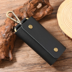 Close-up of black leather key pouch with vintage bronze swivel hook and snap closures