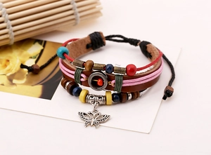 Detail of vintage multilayer leather bracelet with colorful beads and butterfly charm