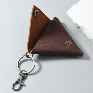 Macro view of brown lychee grain leather triangle coin pouch with silver snap closure