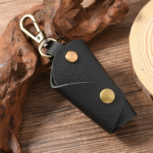Close-up of black lychee grain leather key pouch with vintage brass lobster clasp detail