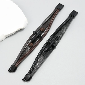 Macro view of multi-layered braided leather bracelets with cross charms and magnetic clasps