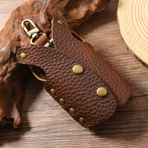 Detail of vintage brown lychee grain leather key pouch with rustic bronze rivets