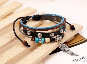 Dettaglio di bracciale in pelle multistrato con ciondolo a piuma d'argento e perline