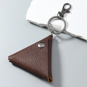 Detail of triangle leather coin purse with pebble grain texture and metal lobster clasp