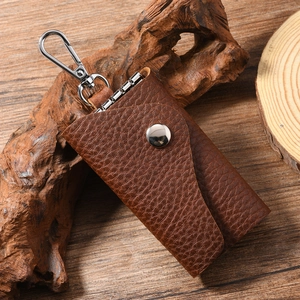 Macro detail of vintage brown lychee grain leather key holder with metal buckle