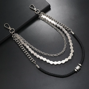 Macro detail of multi-layer punk trouser chains with industrial bicycle link and woven cord