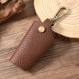 Close-up of retro brown lychee grain leather key pouch with bronze metal snap and hook