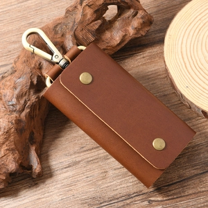 Detail of vintage brown genuine cowhide key case with brass snap buttons and sturdy hook