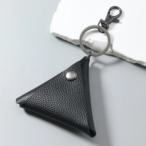 Macro view of triangular black pebble grain leather key fob with metallic snap button