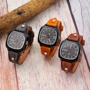 Vintage cuff leather watches with square dials in brown and gray colors on wood background