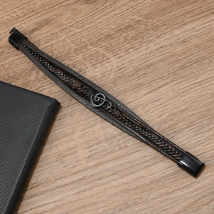 Nahaufnahme eines mehrlagigen Lederarmbands mit einem schwarzen Notenschlüssel-Symbol