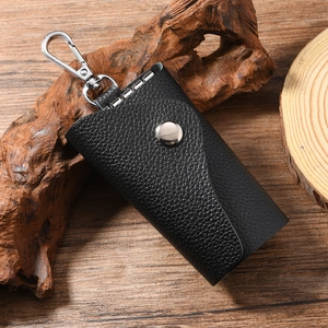 Detailed view of black litchi grain leather key pouch with polished silver swivel clip