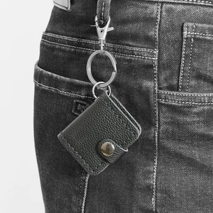 Mini borsa per foto in pelle con motivo litchi appesa al passante dei jeans neri con anello