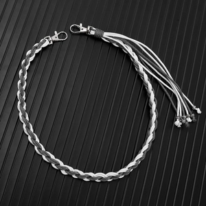 Handmade woven trouser chain with fringe tassels and metallic beads on a dark background