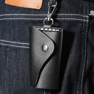 Detail of black pebbled leather key case with silver snap button and swivel carabiner