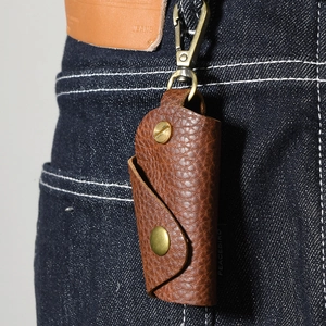 Brown lychee grain leather key pouch hanging on blue jeans with brass metal hook