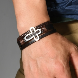 Men's multi-layer braided leather bracelet with silver hollow cross on model's wrist