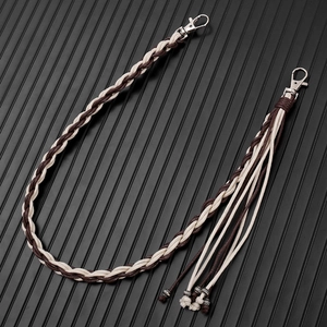 Detail of hand-woven dark brown and beige cord keychain with silver lobster clasp and tassels