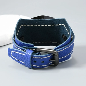 Detail of blue leather cuff with lychee texture and bold white contrast stitching