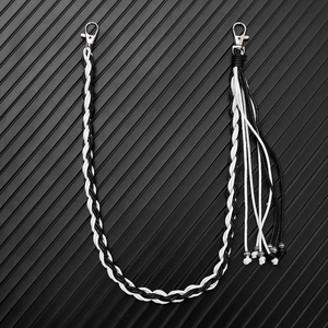 Detail of hand-woven black and white wax cord pant chain with silver lobster clasps and tassel