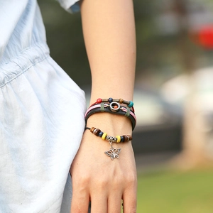 Handmade beaded leather wrap bracelet with colorful beads and a metal butterfly charm