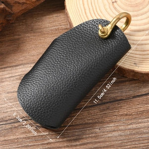 Vintage black lychee pattern leather car key case with brass hook on wooden background