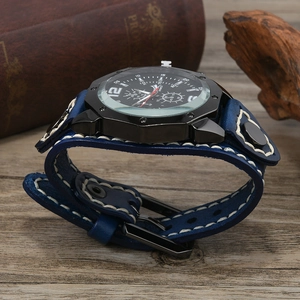 Macro view of blue leather watch strap with white contrast stitching and wide base cuff
