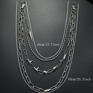 Close-up of triple-layered silver punk waist chain with spikes and bullet pendant