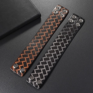 Close-up of retro leather bracelets with herringbone texture and metal snap buttons