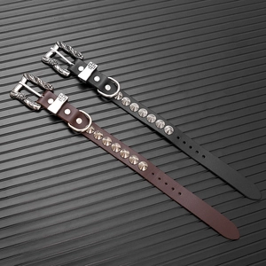 Dettaglio di bracciali punk in pelle con borchie in metallo e fibbie vintage incise