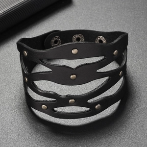 Détail d'un bracelet punk en cuir noir avec des vagues et des rivets métalliques