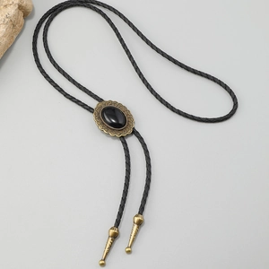 Detail of vintage bronze bolo tie with black gemstone and woven leather cord