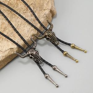 Western bolo tie with vintage ram skull pendant and braided leather cord in gold and silver