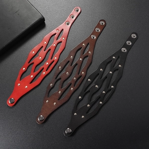 Détail des bracelets en cuir découpé en vagues noir brun et rouge avec rivets en métal