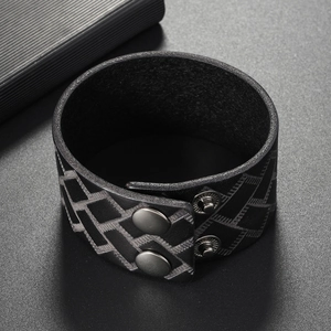 Detailed view of black leather bracelet with geometric weave pattern and silver snap buttons