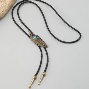Detail of vintage bronze feather bolo tie with turquoise stone on black woven leather