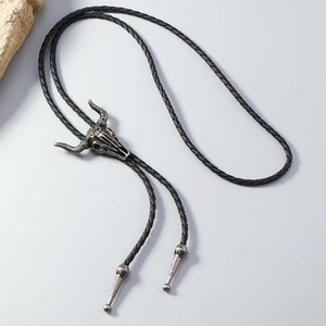 Detail of vintage silver bull skull pendant on black braided western bolo tie necklace