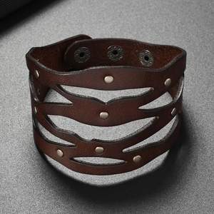 Détail du bracelet punk en cuir large ajustable avec design ajouré et rivets argentés