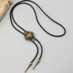 Détail de la cravate bolo vintage avec pendentif fleur en bronze et oeil de tigre