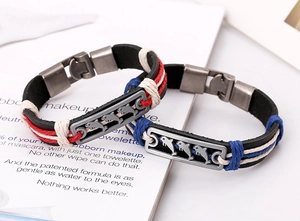 Detail of woven leather bracelets featuring vintage dolphin charms and colorful cord accents