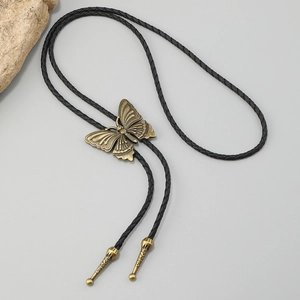 Detail of vintage bronze butterfly slider and black braided leather strap on a Bolo tie