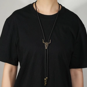 Western cowboy bolo tie featuring a vintage bronze longhorn skull pendant on black cord