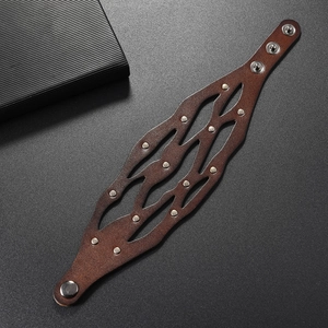 Vue détaillée d'un bracelet large en cuir punk avec rivets métalliques et boutons pression