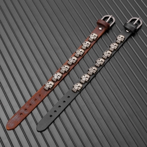 Detail of adjustable leather wristbands with eight vintage skull studs and buckle closure