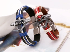 Close-up of woven leather bracelets with silver winged heart charms and Lovely engraving