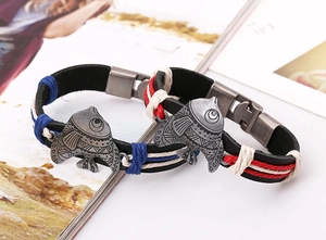 Nahaufnahme der Vintage-Fisch-Anhänger auf geflochtenen Lederarmbändern mit bunten Kordeln