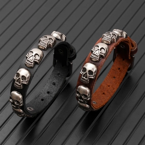 Detailed macro view of black and brown leather skull rivet bracelets with metal studs
